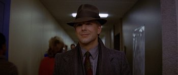 Movie still from “Year of the Dragon” (1985), directed by Michael Cimino – A man wearing a hat and a suit and tie; Close Up shot, Low angle