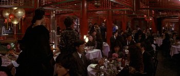 Movie still from “Year of the Dragon” (1985), directed by Michael Cimino – A group of people sitting at tables in a restaurant; Wide shot, High angle