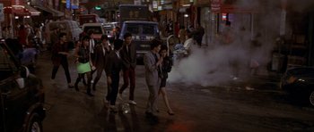 Movie still from “Year of the Dragon” (1985), directed by Michael Cimino – A group of people walking down a street; Wide shot, High angle
