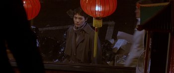 Movie still from “Year of the Dragon” (1985), directed by Michael Cimino – A woman standing in front of a mirror with an oriental lantern; Medium shot, Over the shoulder angle