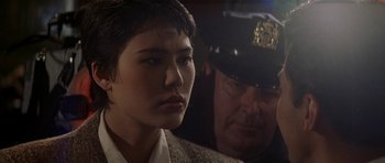 Movie still from “Year of the Dragon” (1985), directed by Michael Cimino – A man and a woman are looking at each other; Close Up shot, Over the shoulder angle
