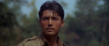Movie still from “Year of the Dragon” (1985), directed by Michael Cimino – A person wearing a brown shirt; Close Up shot, Low angle