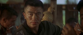 Movie still from “Year of the Dragon” (1985), directed by Michael Cimino – A person wearing a black shirt; Close Up shot, Over the shoulder angle