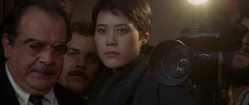 Movie still from “Year of the Dragon” (1985), directed by Michael Cimino – A man and a woman are looking at the camera; Close Up shot, Low angle