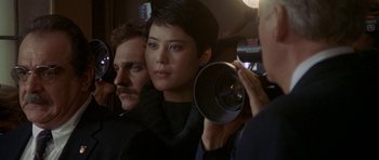 Movie still from “Year of the Dragon” (1985), directed by Michael Cimino – A man and a woman are holding a video camera; Close Up shot, Over the shoulder angle