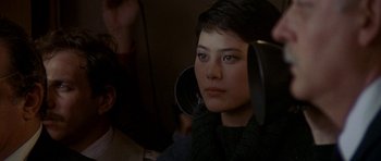 Movie still from “Year of the Dragon” (1985), directed by Michael Cimino – A young woman with short black hair is sitting in front of a mirror; Close Up shot, Over the shoulder angle