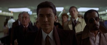 Movie still from “Year of the Dragon” (1985), directed by Michael Cimino – A man in a suit and tie; Close Up shot, Low angle
