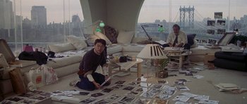 Movie still from “Year of the Dragon” (1985), directed by Michael Cimino – A man sitting on the floor of a living room; Wide shot, High angle