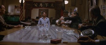 Movie still from “Year of the Dragon” (1985), directed by Michael Cimino – A group of people sitting around a table; Wide shot, High angle