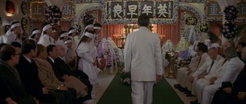 Movie still from “Year of the Dragon” (1985), directed by Michael Cimino – A group of people standing in front of an altar; Wide shot, High angle