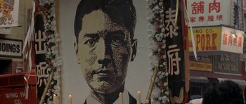 Movie still from “Year of the Dragon” (1985), directed by Michael Cimino – A portrait of a man with candles in front of it; Extreme Close Up shot, Low angle