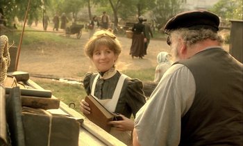 Movie still from “Yentl” (1983), directed by Barbra Streisand – An old fashioned woman holding a book while standing next to an older man; Medium shot, Over the shoulder angle