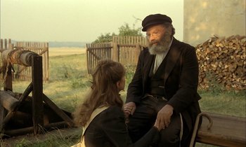 Movie still from “Yentl” (1983), directed by Barbra Streisand – An old man and a young woman sitting on a bench; Medium shot, Over the shoulder angle