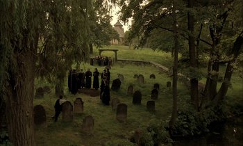 Movie still from “Yentl” (1983), directed by Barbra Streisand – A group of people standing in a cemetery; Extreme Wide shot, High angle