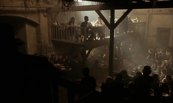 Movie still from “Yentl” (1983), directed by Barbra Streisand – People are sitting on a balcony in an old - fashioned restaurant; Extreme Wide shot, High angle