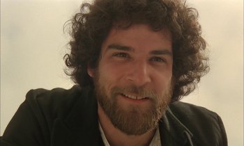 Movie still from “Yentl” (1983), directed by Barbra Streisand – A person with curly hair and a beard; Close Up shot, Low angle