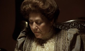 Movie still from “Yentl” (1983), directed by Barbra Streisand – An older woman wearing a dress and a necklace; Close Up shot, High angle