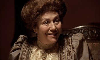 Movie still from “Yentl” (1983), directed by Barbra Streisand – An older woman wearing a wig and a dress; Close Up shot, High angle