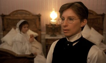 Movie still from “Yentl” (1983), directed by Barbra Streisand – A man wearing glasses standing next to a woman in a room; Close Up shot, Over the shoulder angle