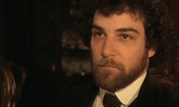 Movie still from “Yentl” (1983), directed by Barbra Streisand – A person wearing a suit and tie; Close Up shot, Over the shoulder angle