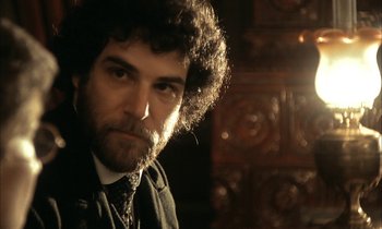 Movie still from “Yentl” (1983), directed by Barbra Streisand – A man with a beard wearing a suit and tie; Close Up shot, Over the shoulder angle