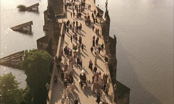 Movie still from “Yentl” (1983), directed by Barbra Streisand – A group of people walking across a bridge over a river; Extreme Wide shot, High angle