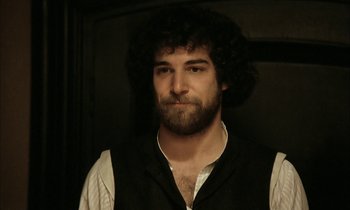 Movie still from “Yentl” (1983), directed by Barbra Streisand – A man with curly hair and a beard; Close Up shot, Over the shoulder angle