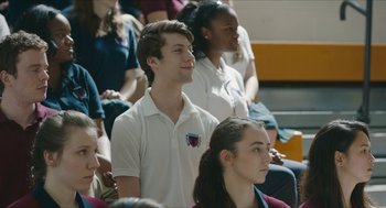Movie still from “Yes, God, Yes” (2019), directed by Karen Maine – A group of young people sitting in a classroom; Medium shot, Over the shoulder angle