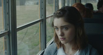 Movie still from “Yes, God, Yes” (2019), directed by Karen Maine – A woman sitting in front of a window looking out; Close Up shot, Over the shoulder angle