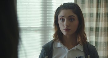 Movie still from “Yes, God, Yes” (2019), directed by Karen Maine – A young woman is standing in front of a window; Close Up shot, Over the shoulder angle
