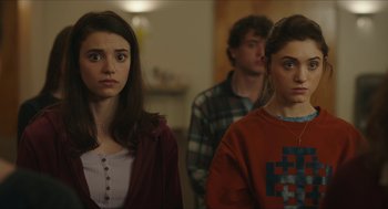 Movie still from “Yes, God, Yes” (2019), directed by Karen Maine – A group of young people standing in a room together; Close Up shot, Over the shoulder angle