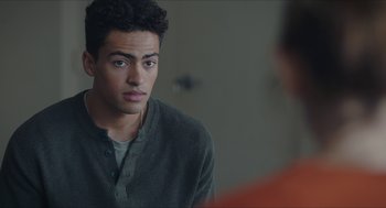 Movie still from “Yes, God, Yes” (2019), directed by Karen Maine – A young man sitting in front of a mirror looking at the camera; Close Up shot, Over the shoulder angle
