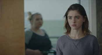 Movie still from “Yes, God, Yes” (2019), directed by Karen Maine – A woman standing in front of a bathroom mirror; Close Up shot, Over the shoulder angle