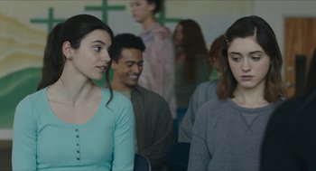 Movie still from “Yes, God, Yes” (2019), directed by Karen Maine – Two young people are sitting in a room; Close Up shot, Over the shoulder angle
