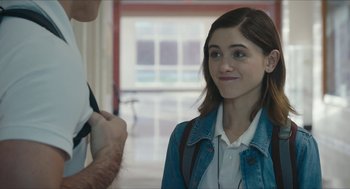 Movie still from “Yes, God, Yes” (2019), directed by Karen Maine – A woman in a white shirt and blue jean jacket looking at a man in a white shirt and blue jean jacket; Close Up shot, Over the shoulder angle