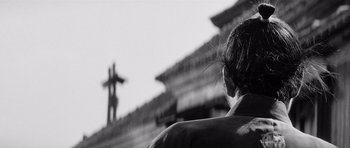 Movie still from “Yojimbo” (1961), directed by Akira Kurosawa – A person is looking at a cross in the background; Close Up shot, Low angle