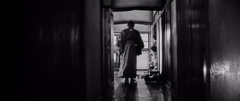 Movie still from “Yojimbo” (1961), directed by Akira Kurosawa – A man in a robe walking down the hall way; Wide shot, Low angle
