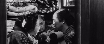 Movie still from “Yojimbo” (1961), directed by Akira Kurosawa – A group of people sitting in a room; Close Up shot, Over the shoulder angle