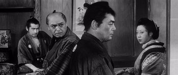 Movie still from “Yojimbo” (1961), directed by Akira Kurosawa – Two men in traditional garb looking at each other; Medium shot, Over the shoulder angle