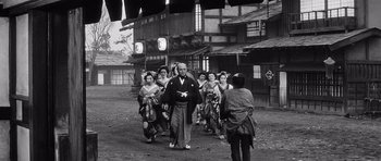 Movie still from “Yojimbo” (1961), directed by Akira Kurosawa – A group of people walking down a street; Wide shot, Low angle