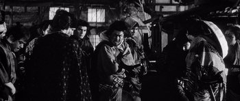 Movie still from “Yojimbo” (1961), directed by Akira Kurosawa – A black and white photo of a group of people; Medium shot, Low angle