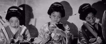 Movie still from “Yojimbo” (1961), directed by Akira Kurosawa – A young woman in a kimono looking at her reflection in a mirror; Close Up shot, Low angle
