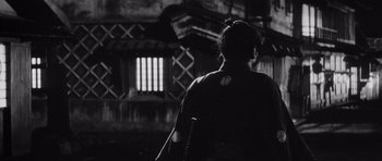 Movie still from “Yojimbo” (1961), directed by Akira Kurosawa – A person with a sword in a dark room; Wide shot, Low angle