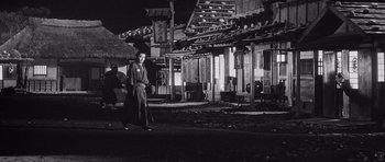 Movie still from “Yojimbo” (1961), directed by Akira Kurosawa – A woman walking down the street at night; Wide shot, Low angle