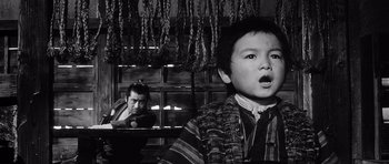 Movie still from “Yojimbo” (1961), directed by Akira Kurosawa – A young boy and a man looking out of a window; Medium shot, Low angle