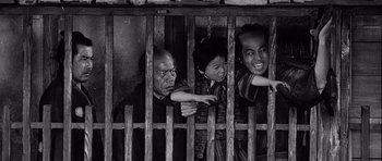 Movie still from “Yojimbo” (1961), directed by Akira Kurosawa – A group of people standing in a cage; Medium shot, Overhead angle
