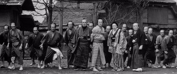 Movie still from “Yojimbo” (1961), directed by Akira Kurosawa – A black and white photo of a group of people in traditional japanese garb; Wide shot, Low angle