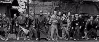 Movie still from “Yojimbo” (1961), directed by Akira Kurosawa – A group of men standing next to each other in front of a building; Wide shot, Low angle
