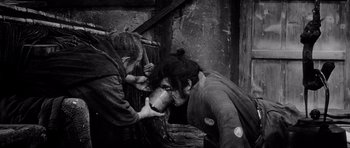 Movie still from “Yojimbo” (1961), directed by Akira Kurosawa – A woman is bending over to drink from a cup; Medium shot, High angle