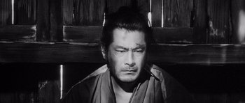 Movie still from “Yojimbo” (1961), directed by Akira Kurosawa – A man with a beard is looking at the camera; Close Up shot, High angle